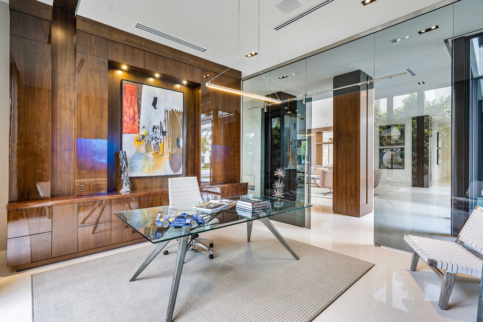 دفتر کار شیشه‌ای با میز شیشه‌ای، صندلی اداری مدرن، کتاب و ماکت ماشین مسابقه‌ای، با دیوار چوبی تزئین‌شده به اثر هنری