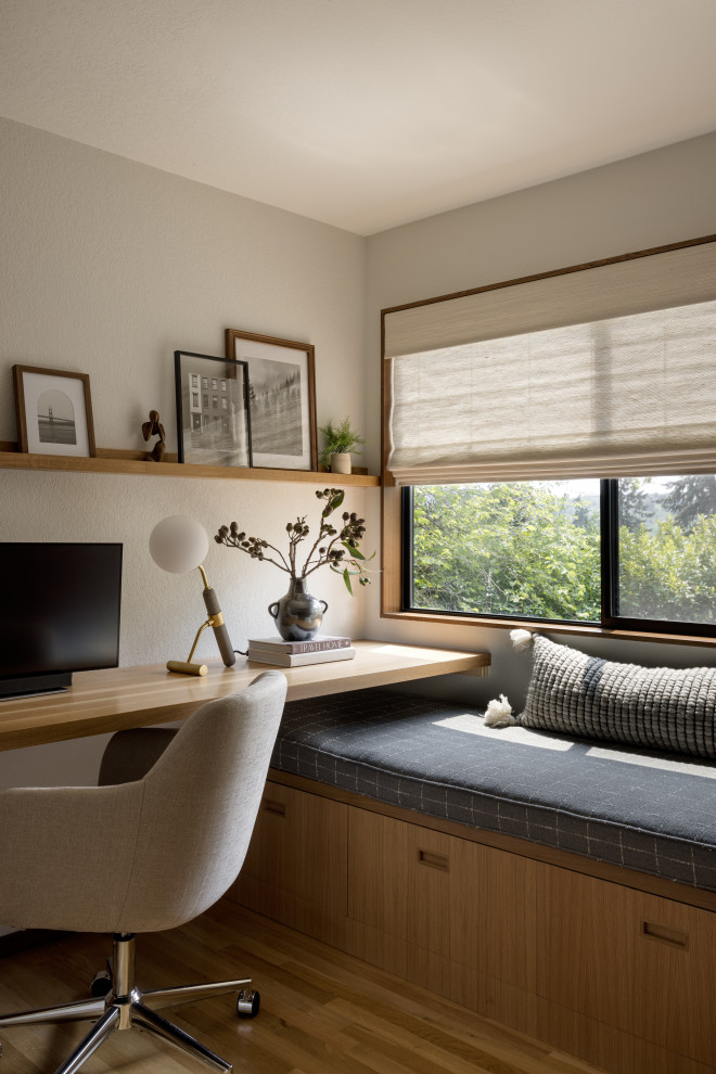 طراحی اتاق مطالعه معاصر با میز کار توکار در اندازه متوسط، کف‌پوش چوبی با رنگ متوسط و دیوارهای کرم، بدون شومینه