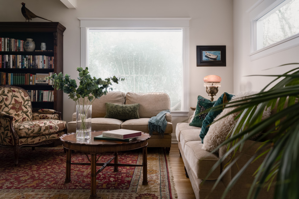 طراحی اتاق نشیمن با مبلمان کرم رنگ، صندلی طرحدار سنتی، قفسه کتاب چوبی، فرش شرقی قرمز، میز عسلی چوبی، نور طبیعی از پنجره‌های بزرگ 