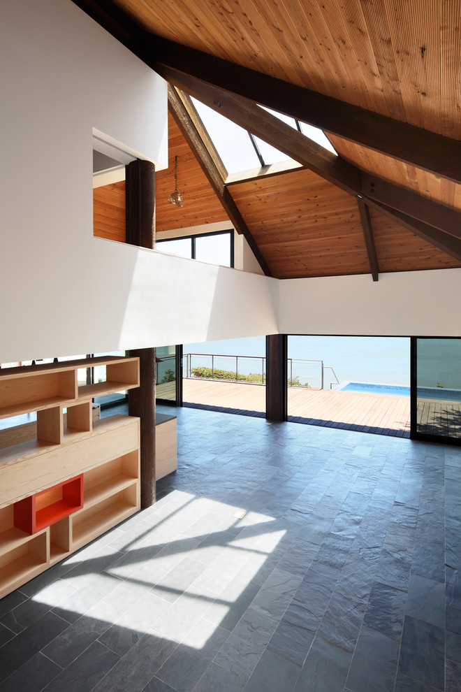 ایده طراحی اتاق نشیمن بزرگ و معاصر با کفپوش سنگ اسلیت و خاکستری، دیوارهای سفید، بدون شومینه و بدون تلویزیون