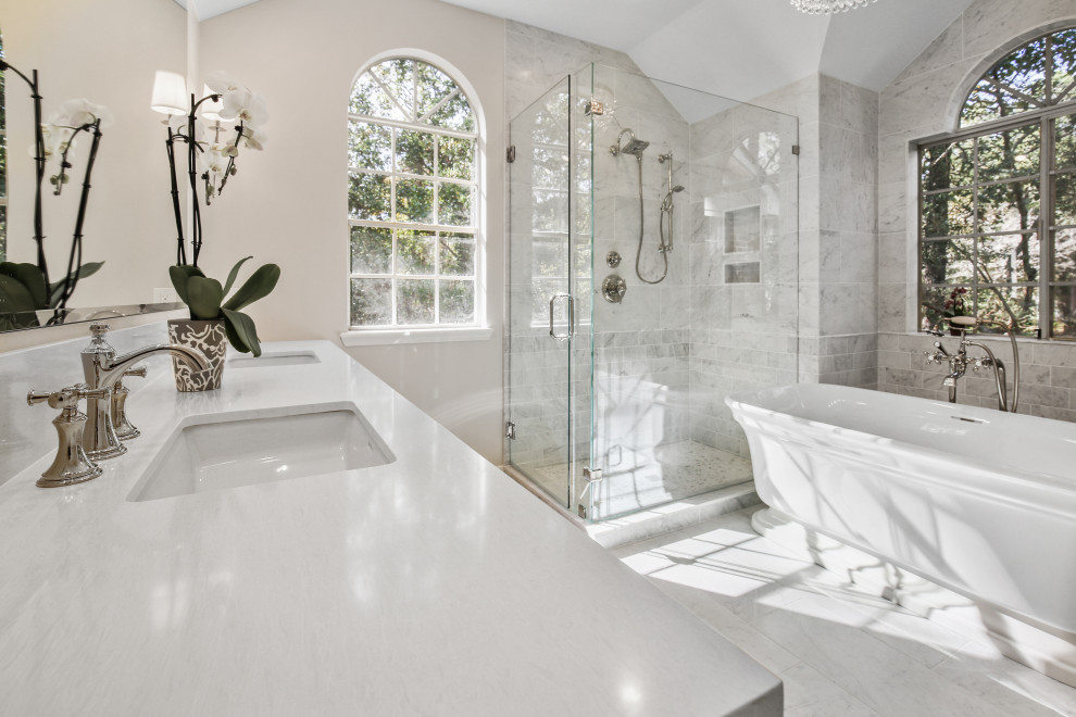 طراحی حمام مستر متوسط سنتی؛ با کاشی مرمر سفید، کف مرمری، دیوارهای خاکستری، توالت فرنگی، روشویی توکار، کانتر کوارتز سفید و درب دوش لولایی.