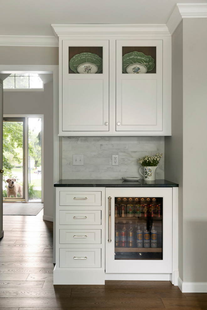 بار خانگی با کف‌پوش چوبی متوسط، کابینت‌های سفید، کانتر کوارتز، بک‌اسپلش چندرنگ با کاشی سیمانی