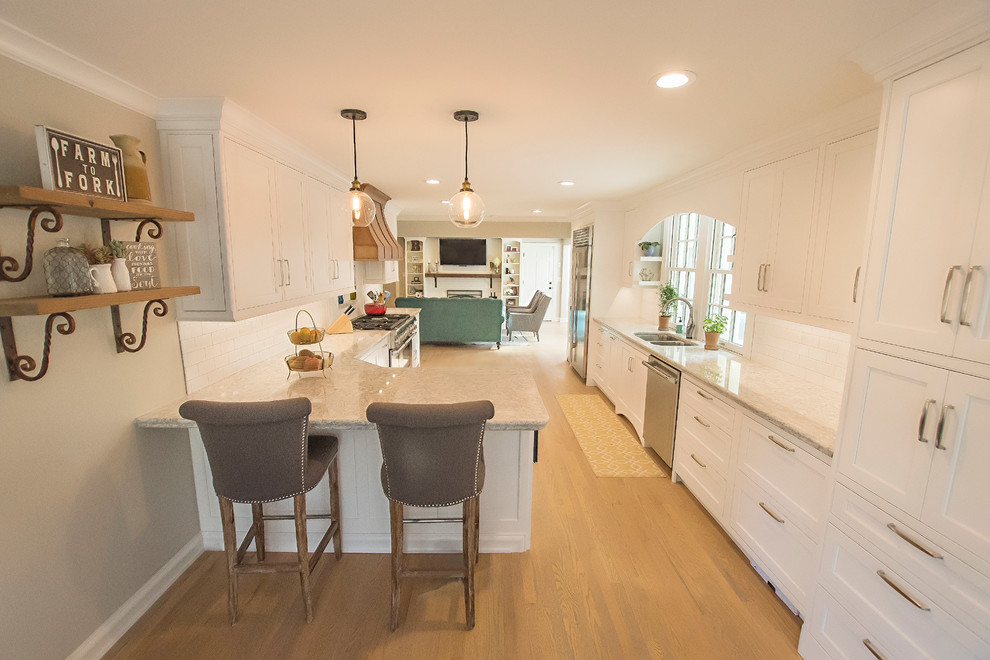 طراحی دیزاین آشپزخانه کلاسیک، کف چوبی روشن، با سینک زیرکابینتی، کابینت‌های سفید با قاب تزئینی، کانترهای کوارتزیت