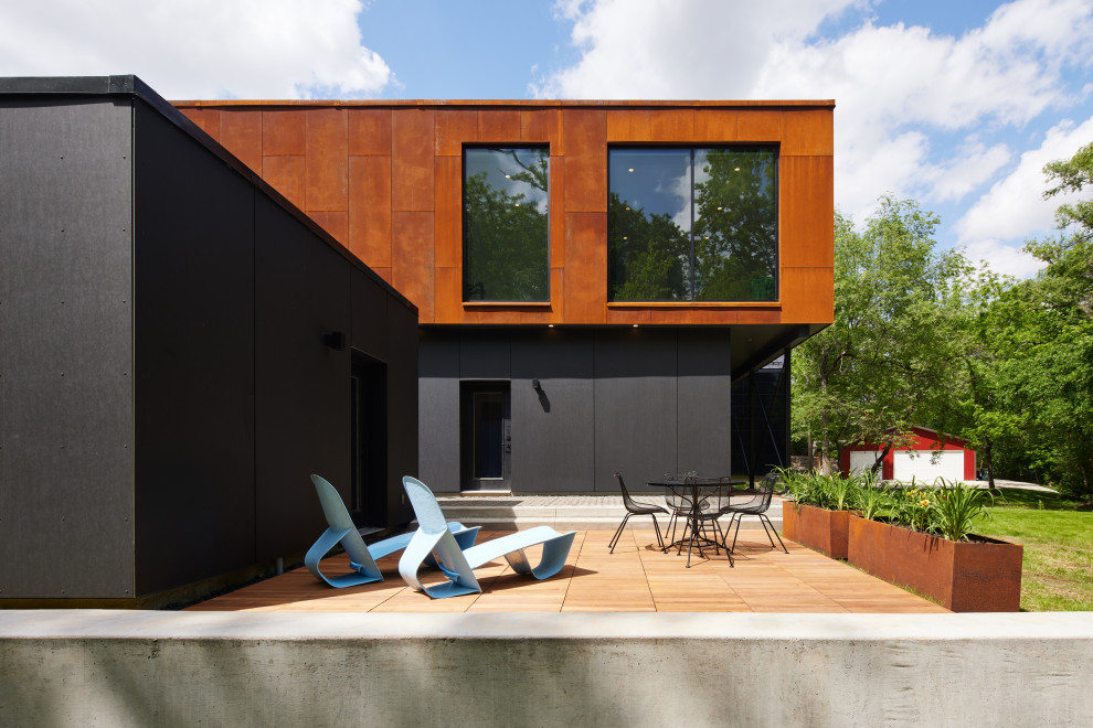 تراس چوبی خانه پایدار با مبلمان مدرن و نمای ترکیبی فلز و چوب در طراحی معاصر - A sustainable home's wooden terrace with modern furniture and a mixed metal and wood façade in contemporary design.