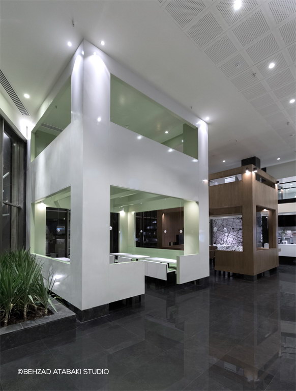 معماری مدرن رستوران با باکس هندسی سفید و سبز، نورپردازی سقفی و فضای نیمه‌خصوصی در طراحی داخلی خلاقانه