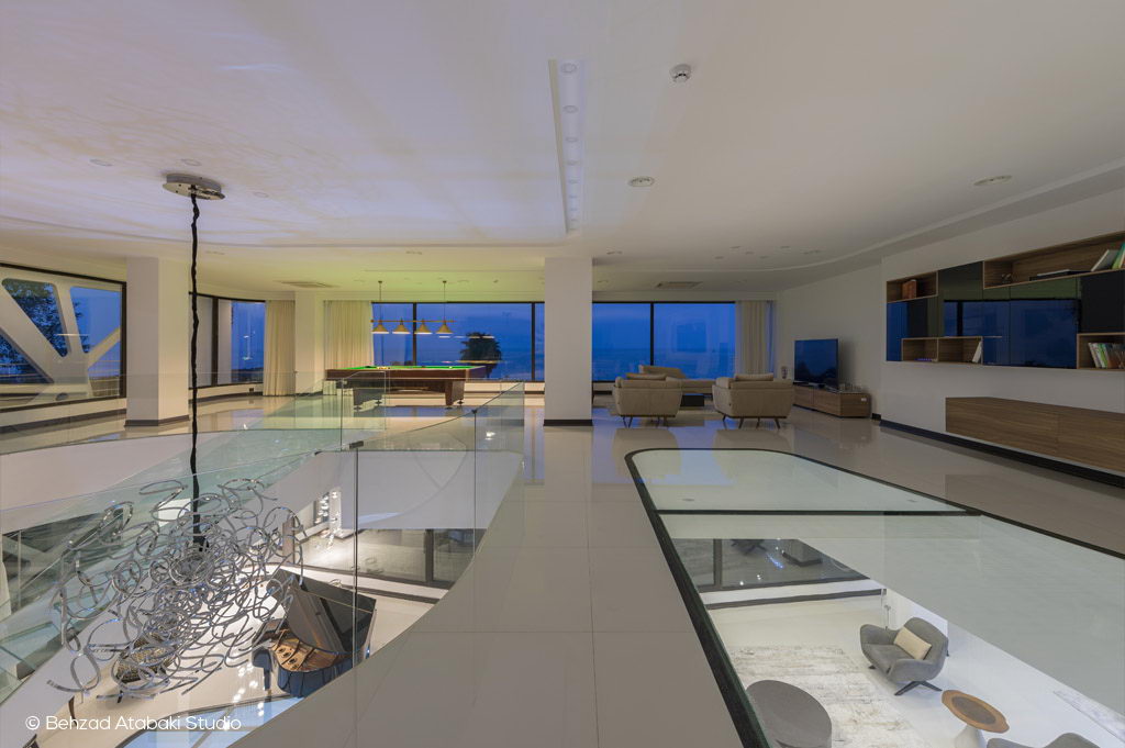 طراحی داخلی ویلای مدرن با پلان باز، نشیمن با دید دریا، میز بیلیارد، کف شیشه‌ای و نورپردازی طبیعی در فضای وسیع